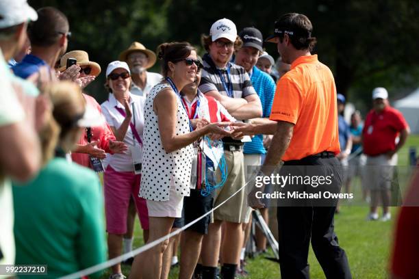 Bubba Watson gives a signed golf ball to a spectator on the 17th hole during round one of A Military Tribute At The Greenbrier at the Old White TPC...