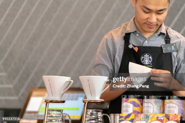 Barista is making coffee in a new Starbucks Reserve coffee shop. At the global investor conference first held in China on May 26, Starbucks announced...