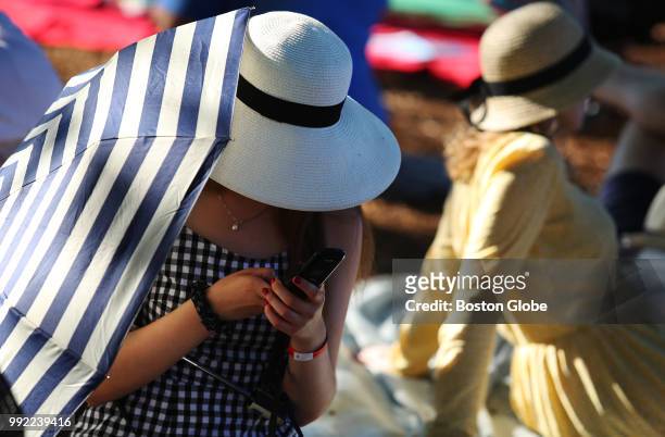 Woman stays out of the sun while waiting for the start of the Boston Pops July 4th Fireworks Spectacular in Boston on July 4, 2018.
