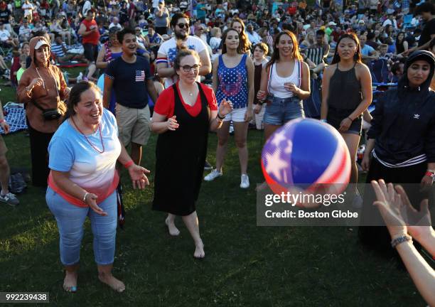 Dina DeAmicis, center, and her sister-in-law Linda started a pick-up game of "keep the ball off the ground" during the Boston Pops July 4th Fireworks...