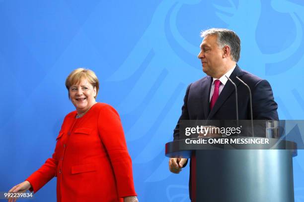 German Chancellor Angela Merkel and Hungarian Prime Minister Viktor Orban leave after a joint press conference following a meeting on July 5, 2018 in...