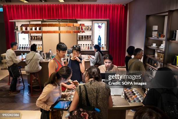 Clients wait in line at the Swiss high-end and world leader in coffee capsules brand, Nespresso, store at Hong Kong's ifc shopping mall in Central...
