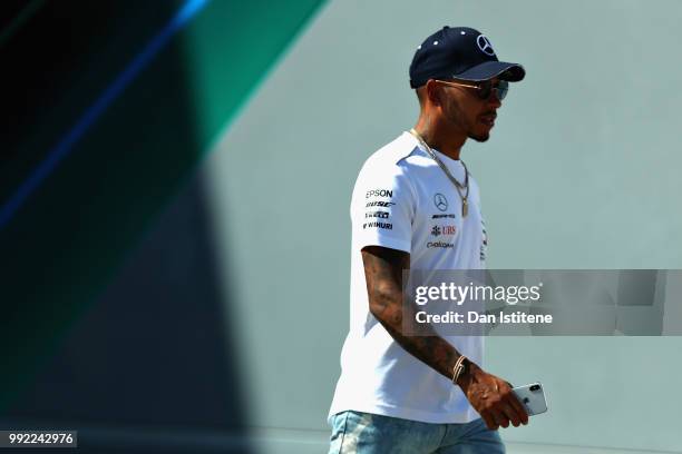 Lewis Hamilton of Great Britain and Mercedes GP walks in the Paddock during previews ahead of the Formula One Grand Prix of Great Britain at...