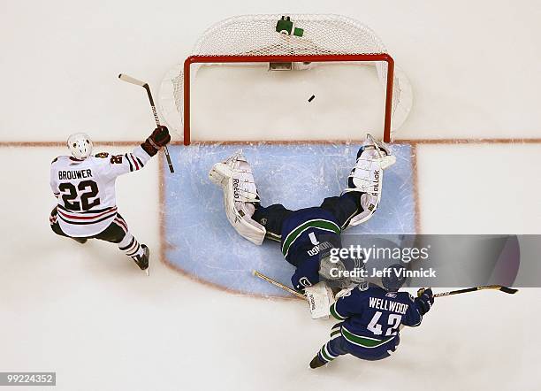 Kyle Wellwood and Roberto Luongo of the Vancouver Canucks look on as Troy Brouwer of the Chicago Blackhawks celebrates his goal in Game 6 of the...