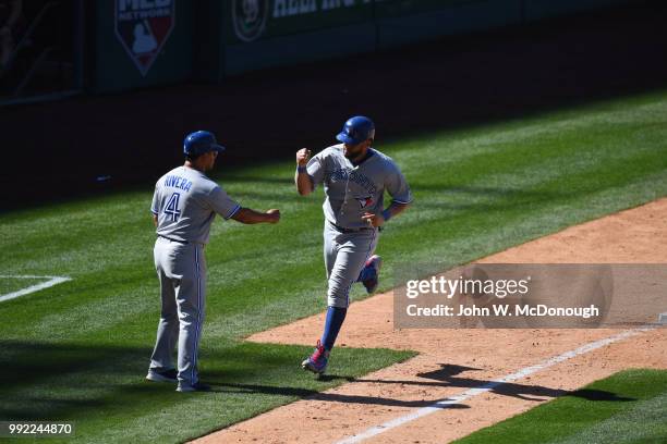 Toronto Blue Jays Kendrys Morales victorious after hitting home run with third base coach Luis Rivera vs Los Angeles Angels at Angel Stadium....