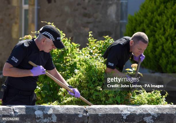 Police officers search a garden in Ardbeg Road on the Isle of Bute in Scotland, after the body of Alesha MacPhail was found in woodland on the site...