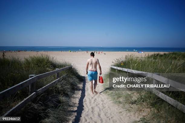 Man walks to the beach on July 5, 2018 in Ouistreham, northwestern France