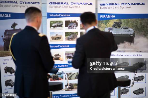 Visitors talking at the stand of the American defence corporation General Dynamics during the Berlin Security Conference on European Security and...