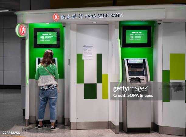 Woman withdraws money from an Hang Seng Bank ATM in Central MTR subway in Hong Kong.
