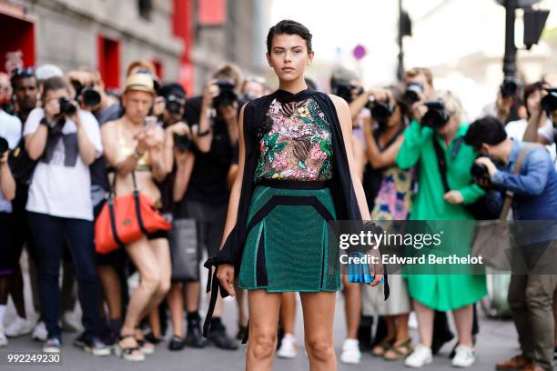 Model Georgia Fowler wears a mesh lace top with colored embroidered flowers, a green skirt, outside Elie Saab, during Paris Fashion Week Haute...