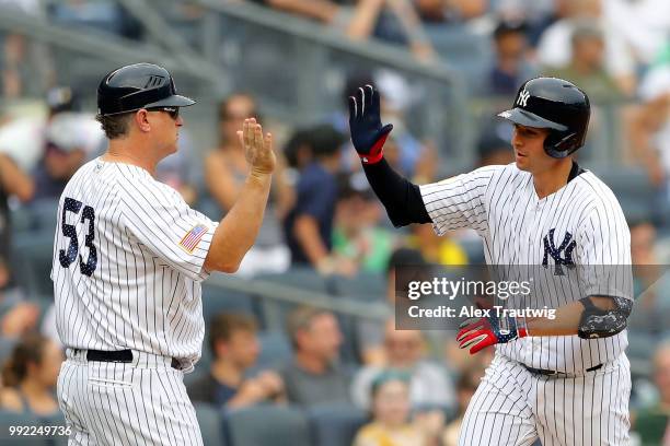 Kyle Higashioka of the New York Yankees celebrates with third base coach Phil Nevin after hitting a home run during a game against the Atlanta Braves...