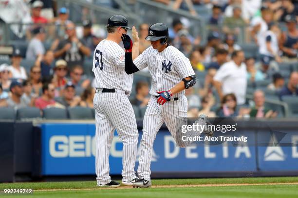 Kyle Higashioka of the New York Yankees celebrates with third base coach Phil Nevin after hitting a home run during a game against the Atlanta Braves...