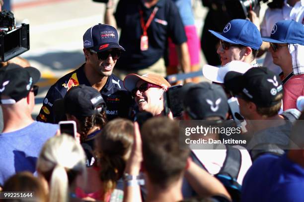 Daniel Ricciardo of Australia and Red Bull Racing signs autographs for fans during previews ahead of the Formula One Grand Prix of Great Britain at...