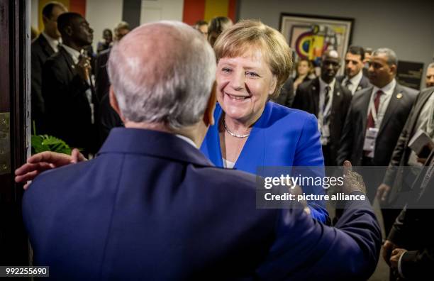 Germany's Chancellor Angela Merkel greets Beji Caid el Sebsi, President of Tunisia, with a hug for his 91st birthday at the Africa-EU summit in...