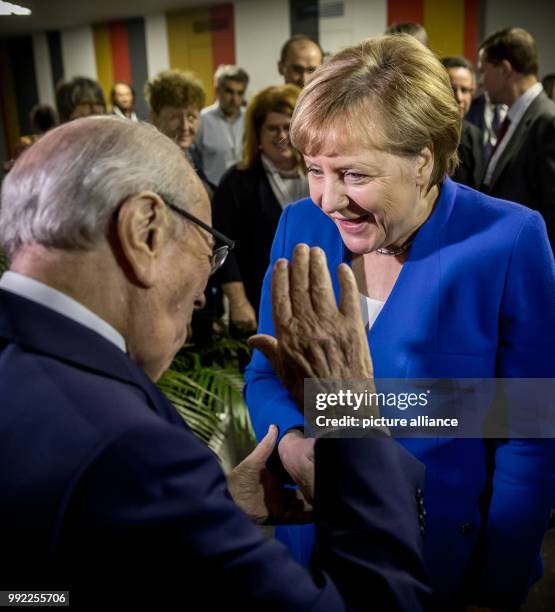 Germany's Chancellor Angela Merkel greets Beji Caid el Sebsi, President of Tunisia, with a hug for his 91st birthday at the Africa-EU summit in...