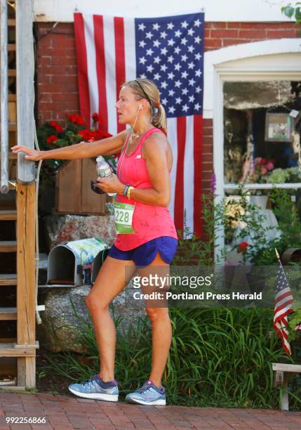 Kursten Tenhoor of Yarmouth recovers in the shade along Bow Street after finishing the L.L. Bean 4th of July 10K for the first time Wednesday.