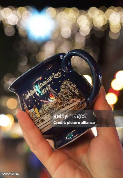 Mulled wine mug with a typo in the word 'Weihnachtsmarkt' , is heald up in Leer, Germany, 21 November 2017. The letter 'K' is missing in the wording...