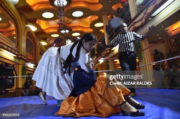 Aymara indigenous women "Martha La Altena" and "Susana La Bonita" take part in a freestyle wrestling flight in El Alto, on June 29, 2018. "Cholita...