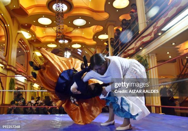 Aymara indigenous women "Martha La Altena" and "Susana La Bonita" take part in a freestyle wrestling flight in El Alto, on June 29, 2018. - "Cholita...