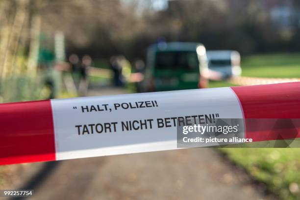 Police barrier tape reading 'Halt, Polizei! Tatort nicht betreten' fences of a path at the Fennpfuhl pond in the district of Britz in Berlin,...