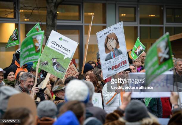 Activists hold up signs with different phrases and pictures during a demonstration organised by differend environmental organisations against...