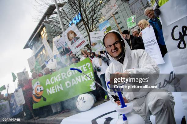 An activist wearing a mask of Minister of Agriculture Schmidt sprays with water during a demonstration organised by differend environmental...