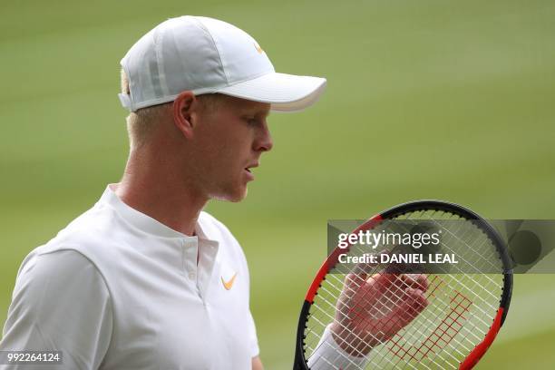 Britain's Kyle Edmund checks his racket as he plays US player Bradley Klahn in their men's singles second round match on the fourth day of the 2018...