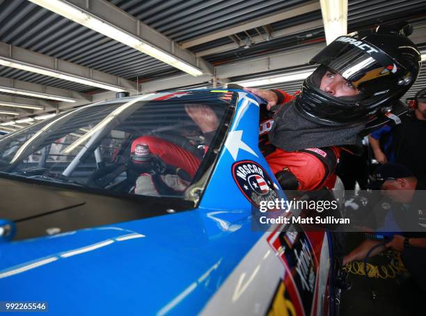 Timmy Hill, driver of the CrashClaimsR.Us Toyota, gets into his car during practice for the NASCAR Xfinity Series Coca-Cola Firecracker 250 at...