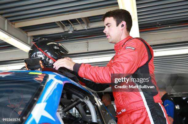 Timmy Hill, driver of the CrashClaimsR.Us Toyota, gets into his car during practice for the NASCAR Xfinity Series Coca-Cola Firecracker 250 at...