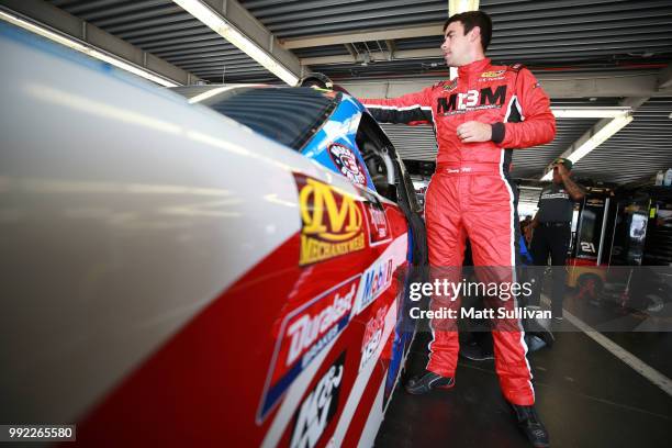 Timmy Hill, driver of the CrashClaimsR.Us Toyota, gets into his car during practice for the NASCAR Xfinity Series Coca-Cola Firecracker 250 at...