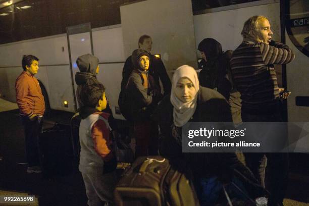 Migrants wait to board a bus at the port of Piraeus in Athens after their arrival with passenger ferry Blue Star 2 from the island of Lesbos, on...