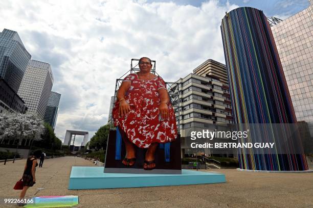 Woman discovers an installation entitled "Auntie Maria" by Indian artist Hanif Kureshi on July 5, 2018 in in Paris' business district La Défense as...