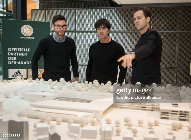 German national team soccer player Jonas Hector , national team head coach Joachim Low and team manager Oliver Bierhoff talking in front of a model...