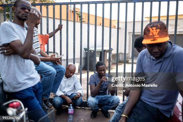 Migrants and refugees stay outside a building after being evicted by Italian Police on July 5, 2018 in Rome, Italy. About 120 African migrants were...