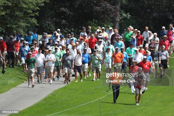 Spectators follow Bubba Watson after hitting his second shot on the sixth hole during round one of A Military Tribute At The Greenbrier held at the...