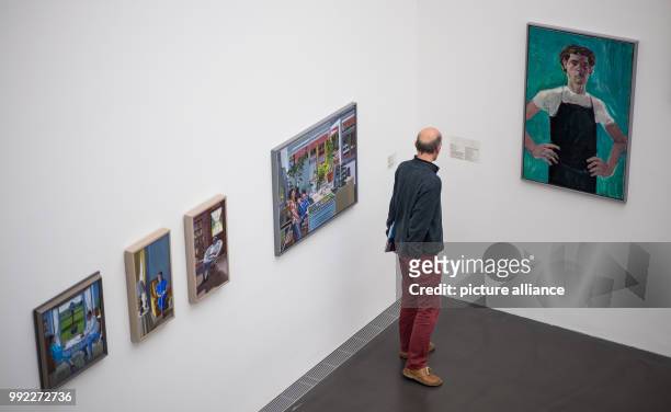 Visitor stands in front of different paintings during a press preview of the exhibition 'Patrick Angus. Private Show' at the Kunstmuseum in...