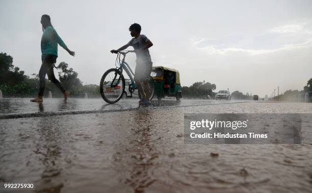People commute during rain at Rajpath on July 5, 2018 in New Delhi, India.