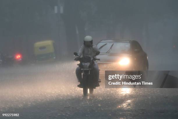 People drive amid heavy monsoon rain at KG Marg, on July 5, 2018 in New Delhi, India.