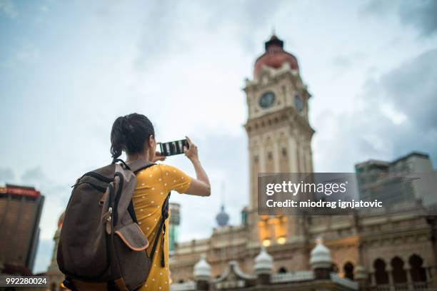 woman taking a picture of the sultan abdul samad building - dataran merdeka stock pictures, royalty-free photos & images