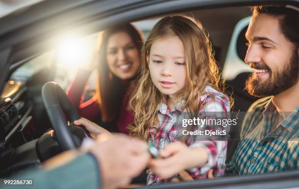 happy young family buying their new car. - car shopping stock pictures, royalty-free photos & images