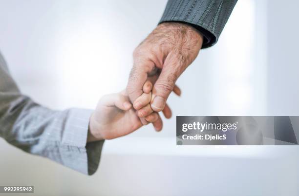 close-up van de hand van opa en kleindochter hand in hand. - child hand stockfoto's en -beelden