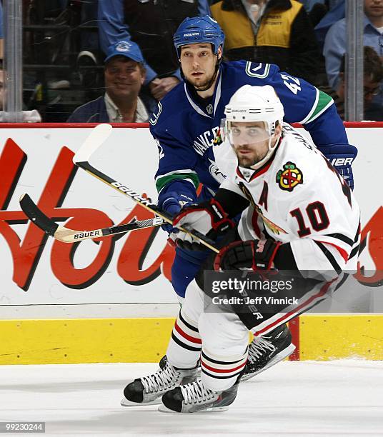 Patrick Sharp of the Chicago Blackhawks and Kyle Wellwood of the Vancouver Canucks skate up ice in Game 6 of the Western Conference Semifinals during...