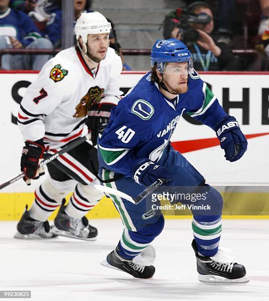 Brent Seabrook of the Chicago Blackhawks and Michael Grabner of the Vancouver Canucks skate up ice in Game 6 of the Western Conference Semifinals...