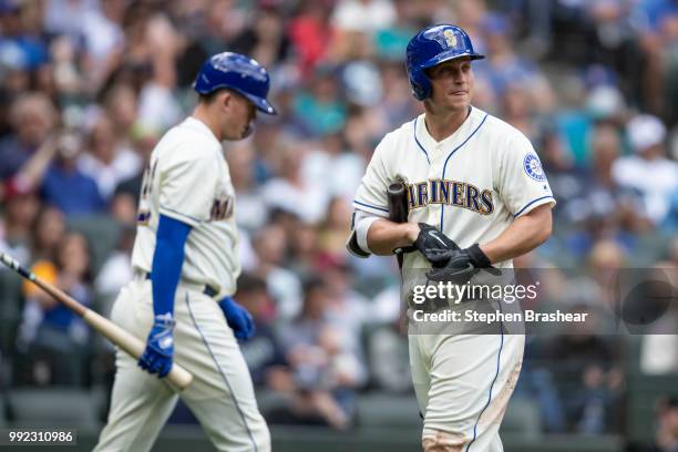 Kyle Seager, right, of the Seattle Mariners walks off the field after an at-bat as Ryon Healy of the Seattle Mariners walks to the batter's box...