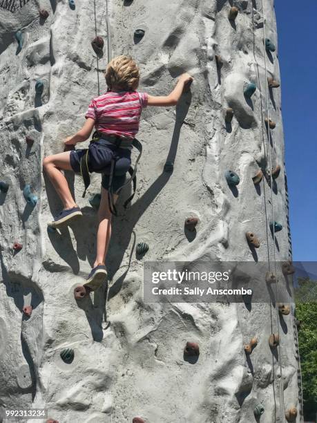 child climbing on a climbing wall - sally anscombe stock-fotos und bilder