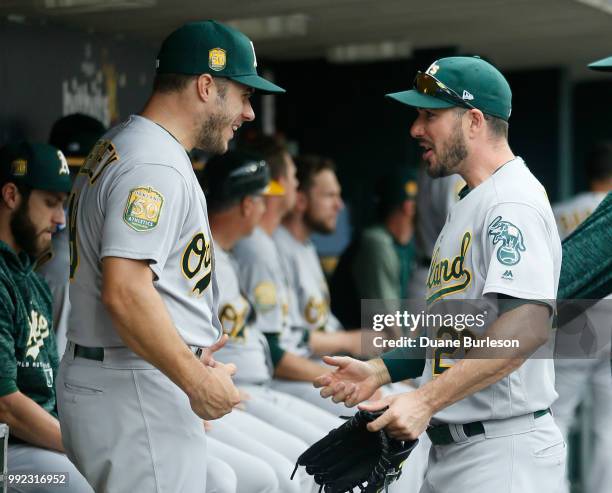 Josh Phegley of the Oakland Athletics and Matt Joyce of the Oakland Athletics joke around in the dugout before a game against the Detroit Tigers at...