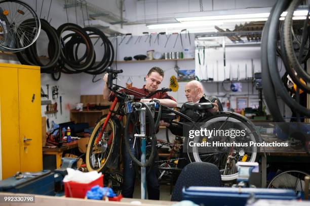 bicycle mechanics working together - hinterhaus stockfoto's en -beelden