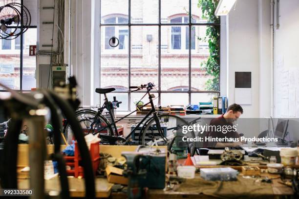 bicycle workshop technician doing administrative work - sportgeschäft stock-fotos und bilder