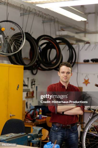 portrait of bicycle technician in workshop - hinterhaus stockfoto's en -beelden