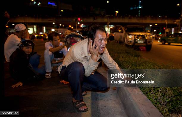 Thais seek cover during a brief clash with soldiers near Lumphini Park on May 13, 2010 in central Bangkok, Thailand. The Black Shirt Guards are used...